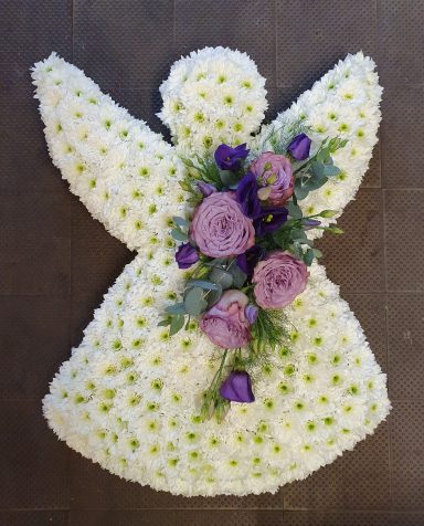 Floral arrangement shaped as an angel, featuring white flowers with purple and lilac accents.